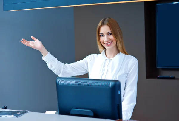 Aantrekkelijke vrouw receptioniste vriendelijk gebaar maken — Stockfoto