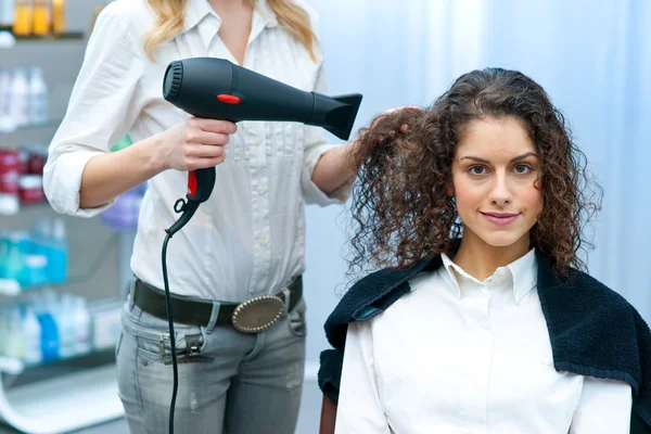 Estilista secado mujer cabello en salón — Foto de Stock
