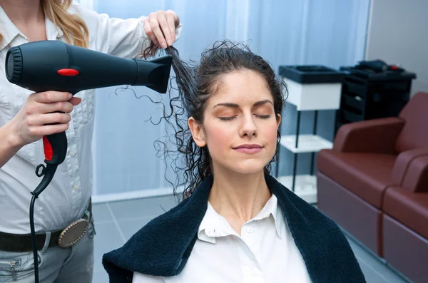 Estilista secagem mulher cabelo no salão — Fotografia de Stock