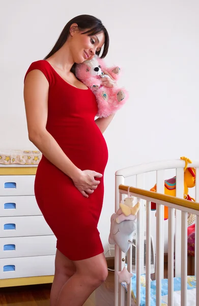 Pregnant woman near baby cot — Stock Photo, Image