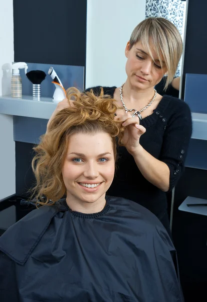 Hair stylist curling woman hair — Stock Photo, Image