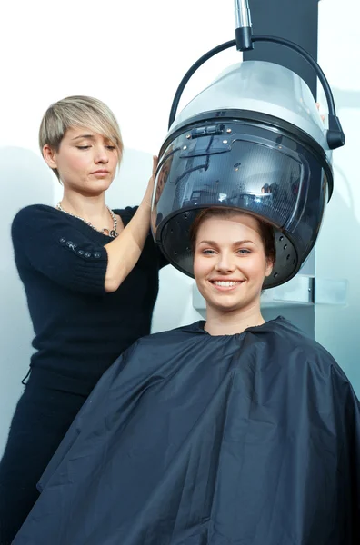 Woman using hair dryer Royalty Free Stock Images