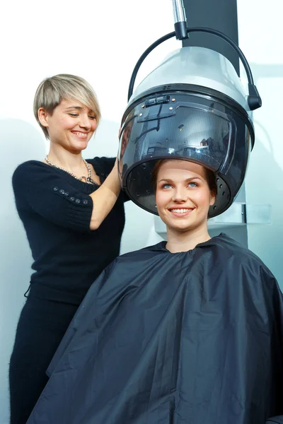 Woman using hair dryer Stock Picture