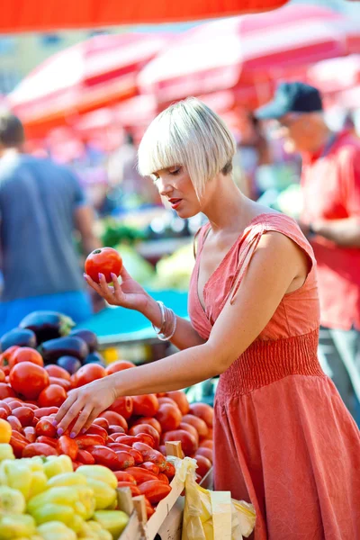 Woman on market place with vegetables Royalty Free Stock Photos