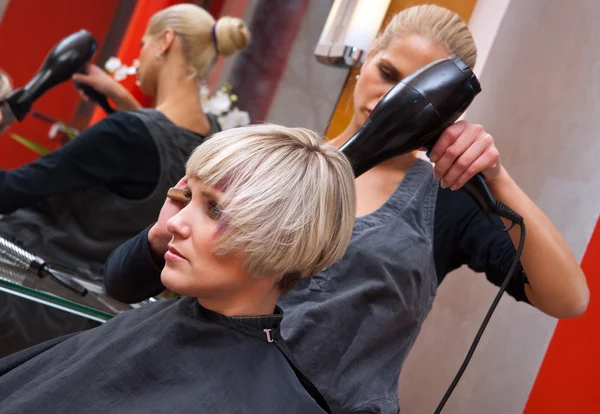 Stylist secagem mulher cabelo — Fotografia de Stock