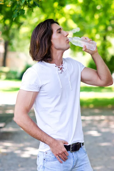 Man drinks water from bottle — Stock Photo, Image