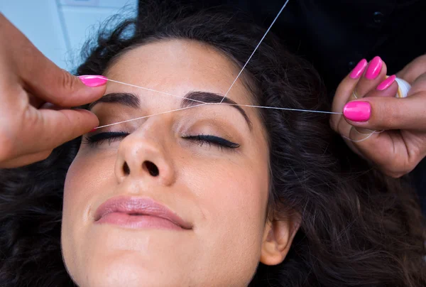 Vrouw op gezichtshaar verwijderen threading procedure — Stockfoto