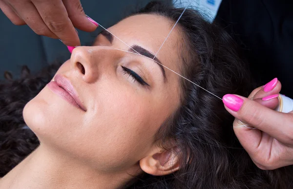 Vrouw op gezichtshaar verwijderen threading procedure — Stockfoto