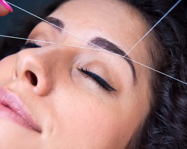 Vrouw op gezichtshaar verwijderen threading procedure — Stockfoto