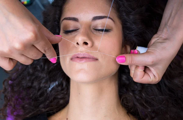 Vrouw op gezichtshaar verwijderen threading procedure — Stockfoto