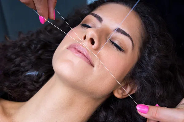 Mulher na remoção de pêlos faciais procedimento de rosqueamento — Fotografia de Stock