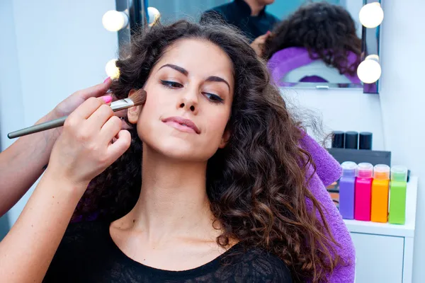 Woman putting make up — Stockfoto