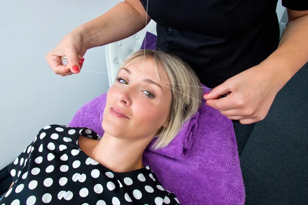 Mulher que tem rosqueamento procedimento de remoção de cabelo — Fotografia de Stock