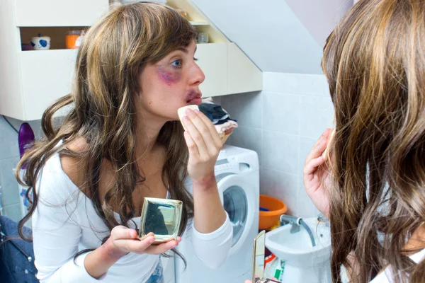 Mulher cobrindo hematomas com maquiagem — Fotografia de Stock