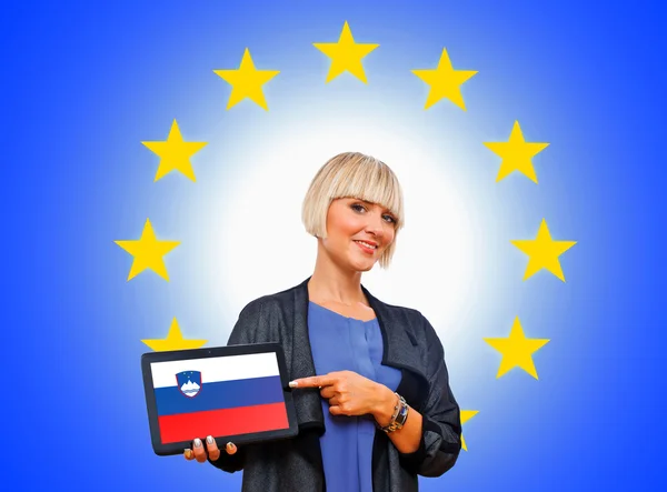 Kvinna anläggning tablett med slovenska flaggan på Europeiska unionen tillbaka — Stockfoto
