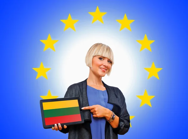 Mujer sosteniendo tableta con bandera de lithuania en la Unión Europea espalda — Foto de Stock