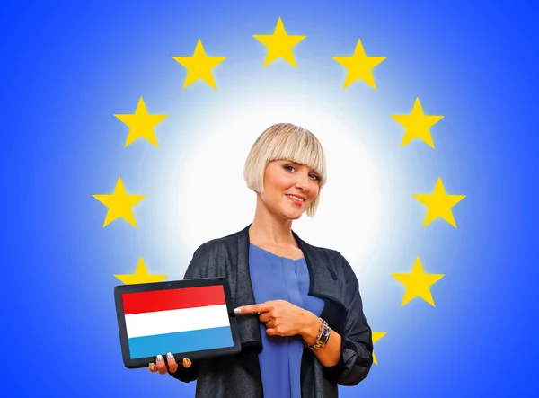 Frau mit Tablette mit luxemburgischer Flagge auf europäischem Union-Bac — Stockfoto