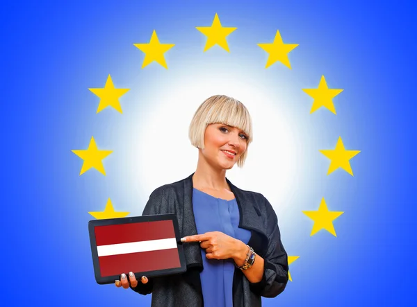 Woman holding tablet with latvian flag on european union backgr — Stock Photo, Image
