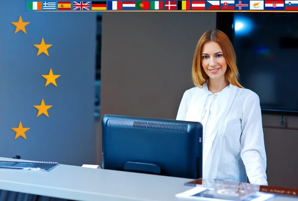 Vrouw bij de receptie met Europese vlaggen — Stockfoto