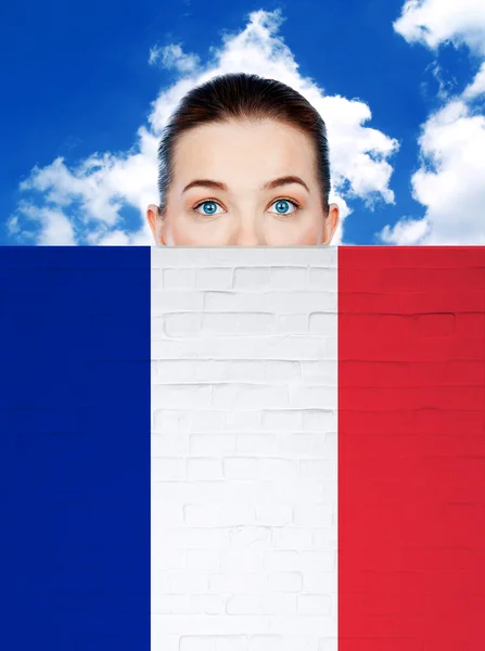 Γυναίκα πρόσωπο πίσω από τον τοίχο με τη σημαία της Γαλλίας — Φωτογραφία Αρχείου
