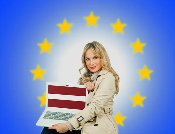 Woman holding laptop with latvian flag — Stock Photo, Image