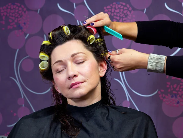 Kapper rollen aanbrengend vrouw haar — Stockfoto