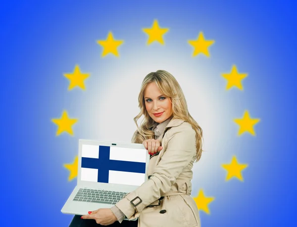Kobieta trzyma laptopa z banderą Finlandii — Zdjęcie stockowe
