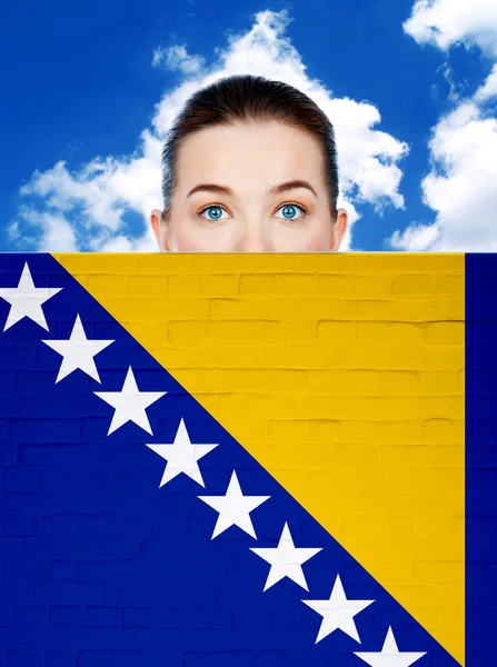 Woman face behind wall with Bosnia and Herzegovina flag — Stock Photo, Image