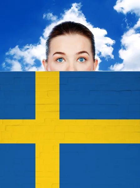 Γυναίκα πρόσωπο πίσω από τον τοίχο με σημαία Σουηδίας — Φωτογραφία Αρχείου