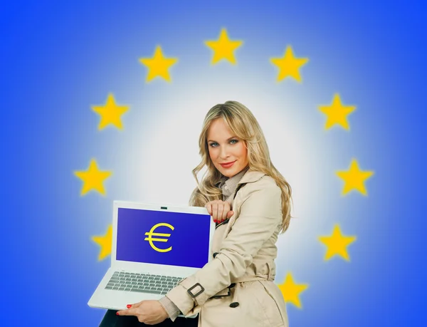 Atractiva mujer sosteniendo el ordenador portátil con signo de euro en la pantalla — Foto de Stock