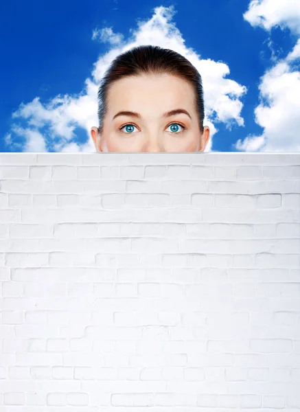 Teen girl face behind wall — Stock Photo, Image