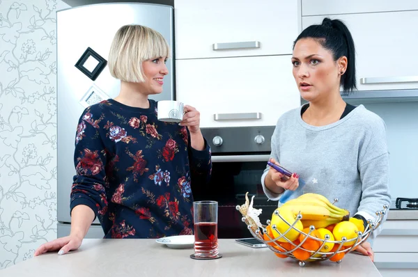 Twee aantrekkelijke vrouw vrienden drinken van koffie en praten — Stockfoto