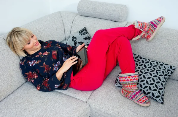 Attraktive Frau mit Tablet auf dem Sofa bei hoime — Stockfoto