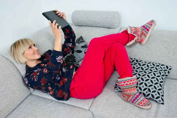 Mulher atraente usando tablet no sofá no hoime — Fotografia de Stock