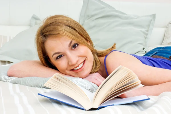 Mujer leyendo libro en la cama Imagen de stock