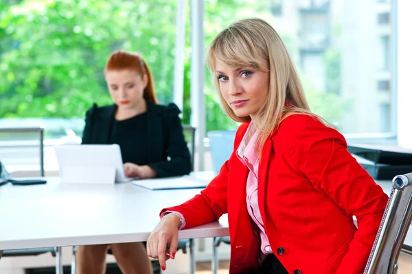Attraente donna d'affari in carica con collega in background — Foto Stock