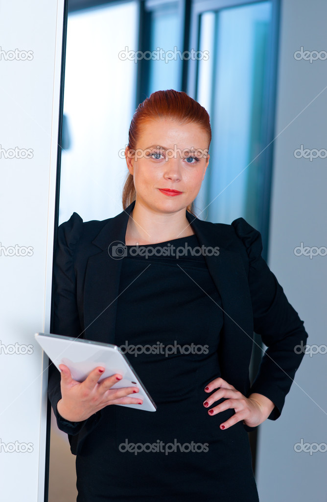 red hair business woman with tablet in office