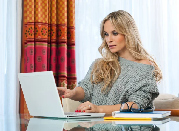 Attraktive blonde Frau schreibt auf Laptop — Stockfoto