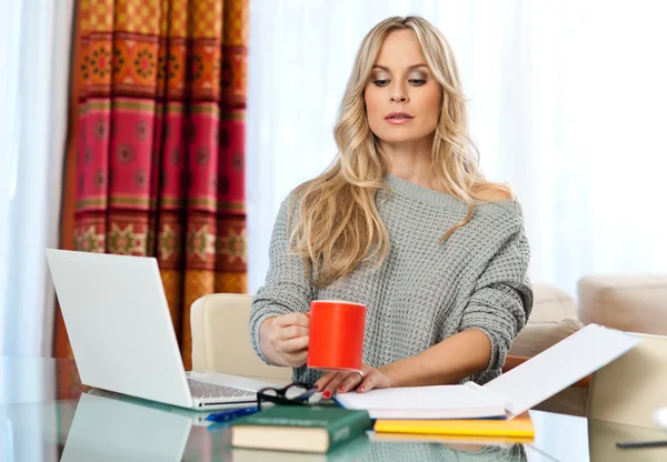 Attraktive blonde Frau schreibt auf Laptop — Stockfoto