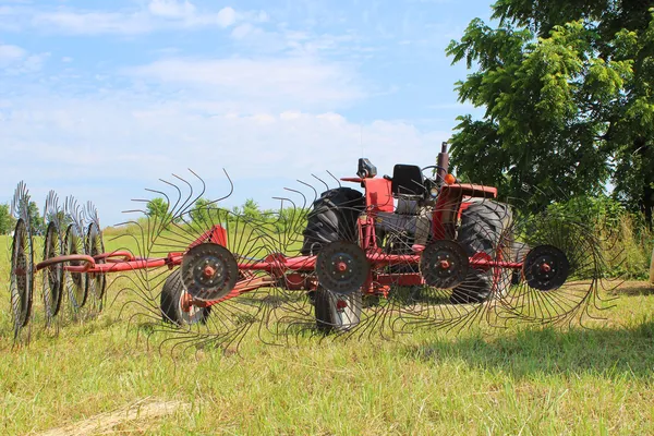 Trator em campo com Hay Rake — Fotografia de Stock