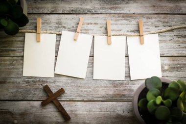 Ahşap bir arka planda, bitkiler ve Hristiyan haçı olan özel bir mesaj için 4 adet boş kart..