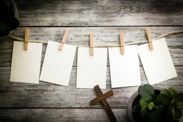 Ahşap bir arka planda, üzerinde bitkiler ve Hristiyan haçı olan özel bir mesaj için 5 adet boş kart..