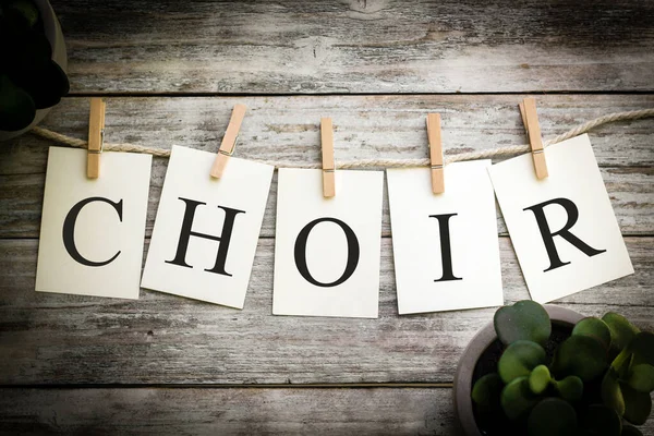 stock image A set of printed cards spelling the word CHOIR on an aged wooden background.