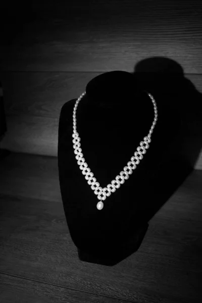 Pearl necklace, vintage luxury accssory on wooden background. Black and white