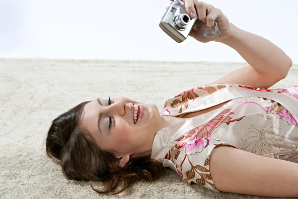 Mulher olhando para uma câmera fotográfica digital — Fotografia de Stock