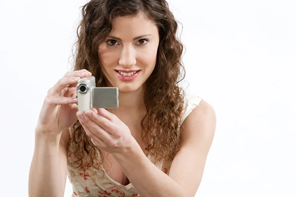 Женщина держит цифровую видеокамеру перед лицом — стоковое фото
