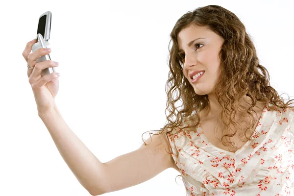 Young woman holding a cell phone in the air — Stock Photo, Image