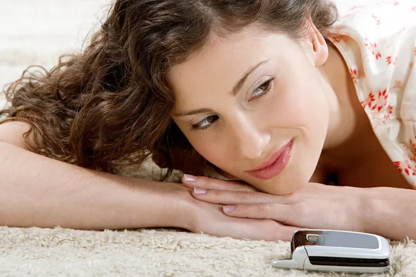 Young hispanic woman laying down on a furry carpet at home — Stock Photo, Image