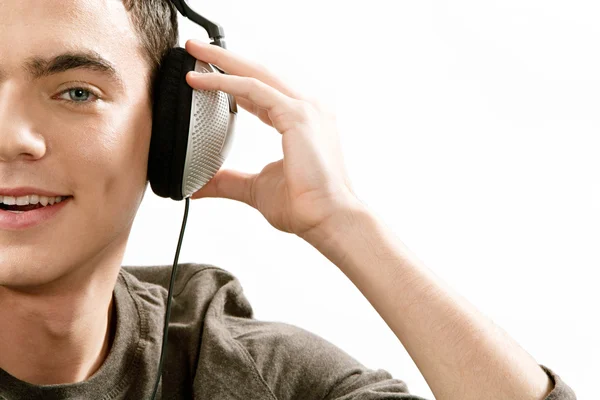 Jonge man halve gezicht muziek beluisteren — Stockfoto
