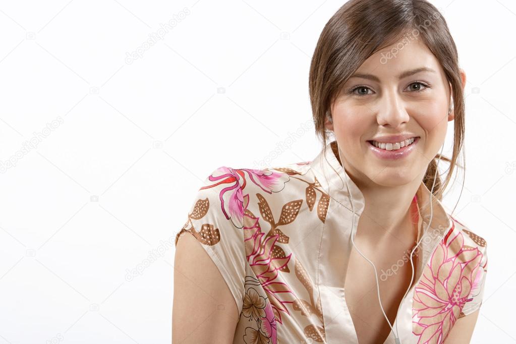 young smiling woman listening to music with her ear phones